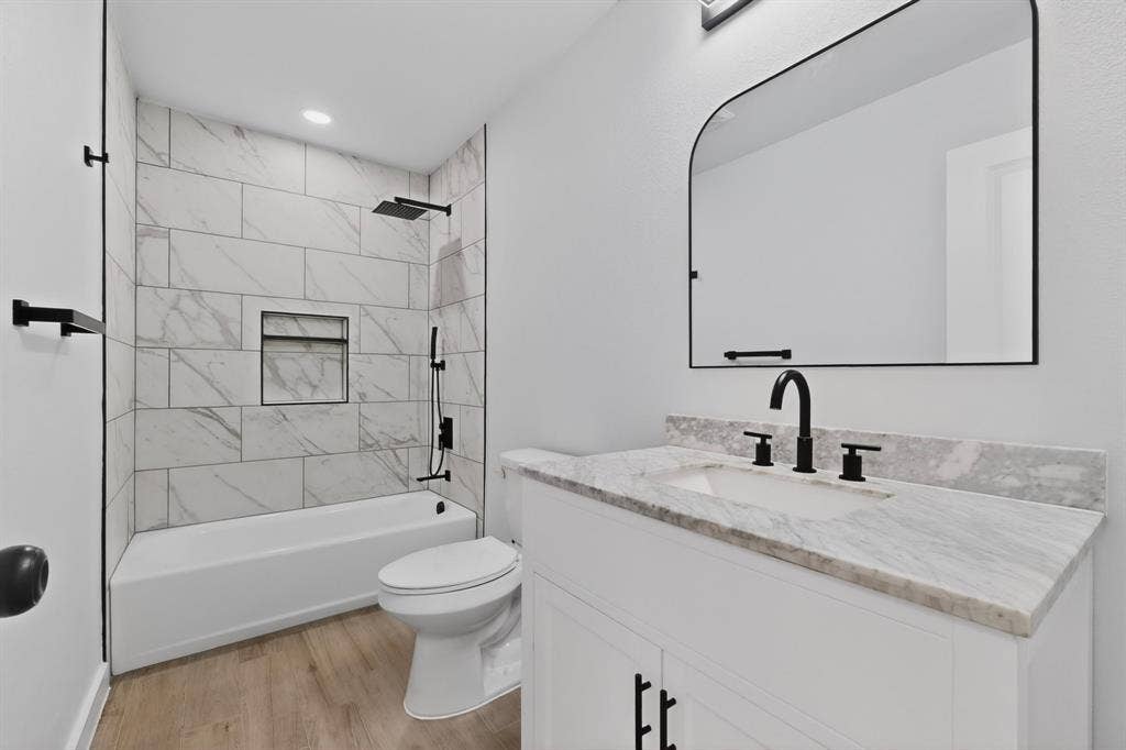 3853 Happy Canyon Drive, Dallas, TX 75241 Bathroom featuring a white vanity with a stone countertop, an undermount sink, and matte black fixtures