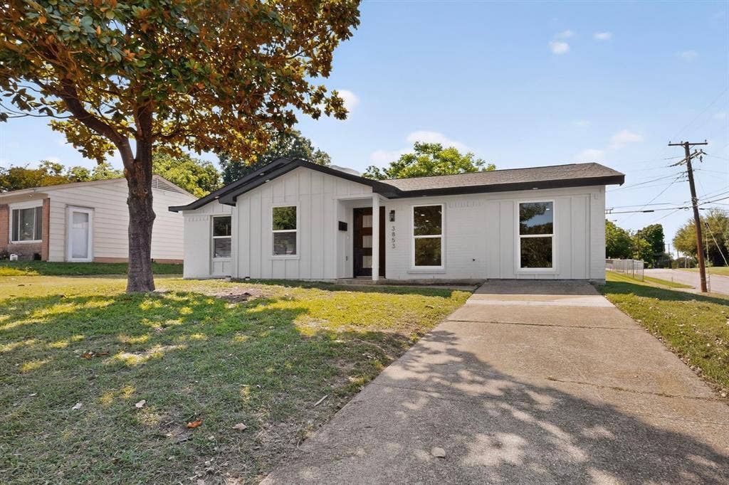 3853 Happy Canyon Drive, Dallas, TX 75241 Modern ranch-style home featuring a light gray exterior, dark trim, and a black front door