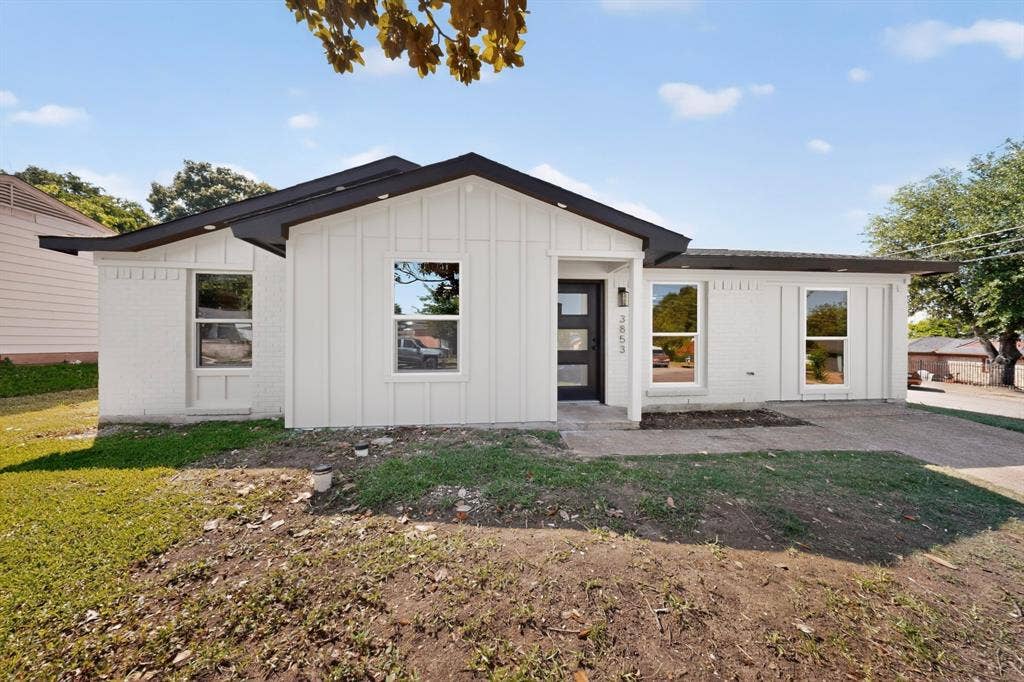 3853 Happy Canyon Drive, Dallas, TX 75241 Modern exterior featuring white board and batten siding, white painted brick, a black roof, and a contemporary black entry door with frosted glass panels