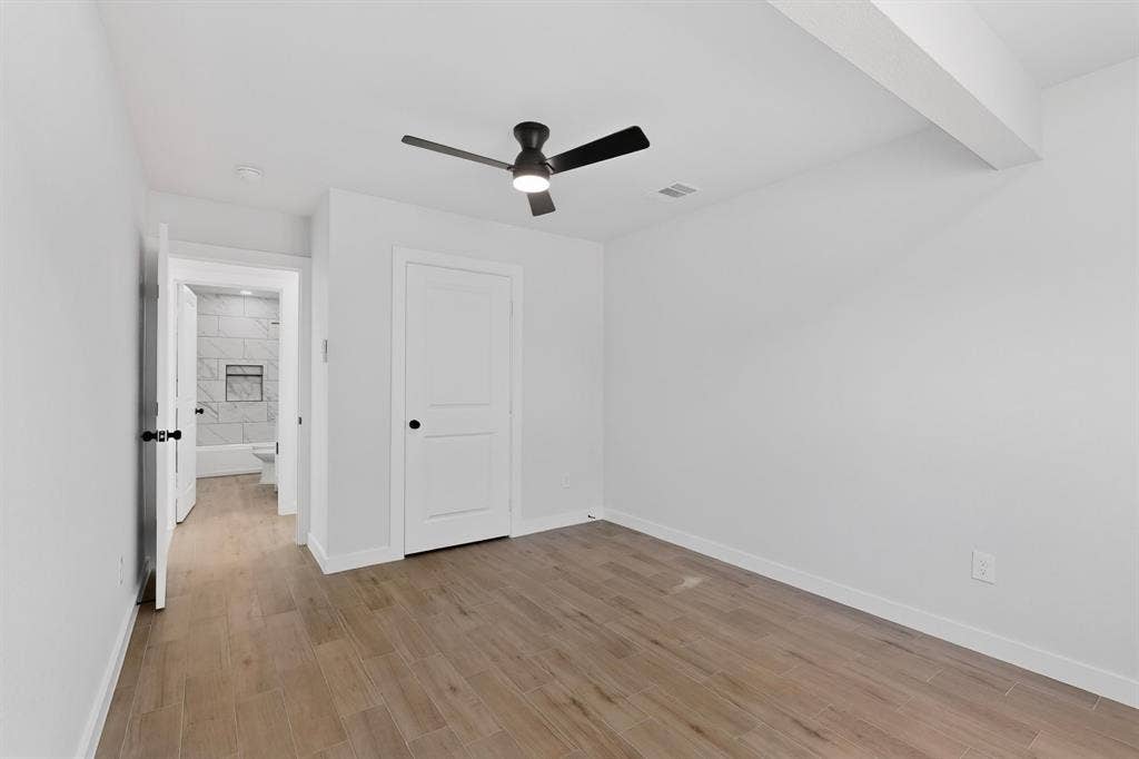 3853 Happy Canyon Drive, Dallas, TX 75241 Room featuring wood-finish flooring, a contemporary ceiling fan with integrated lighting, and a white interior door with black hardware