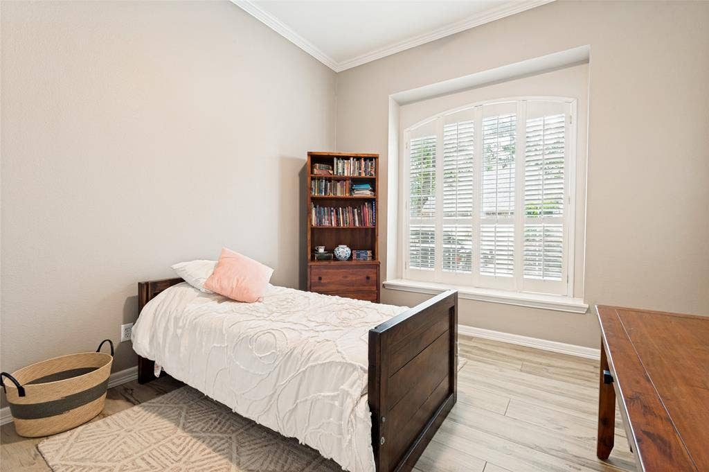 108 Appalachian Way, McKinney, TX 75071 Arched window with plantation shutters, light wood-finish flooring, crown molding, and neutral wall tones