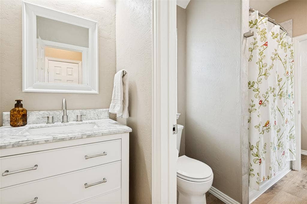 108 Appalachian Way, McKinney, TX 75071 Bathroom featuring a white vanity with an undermount sink, a stone-finish countertop, and brushed nickel hardware