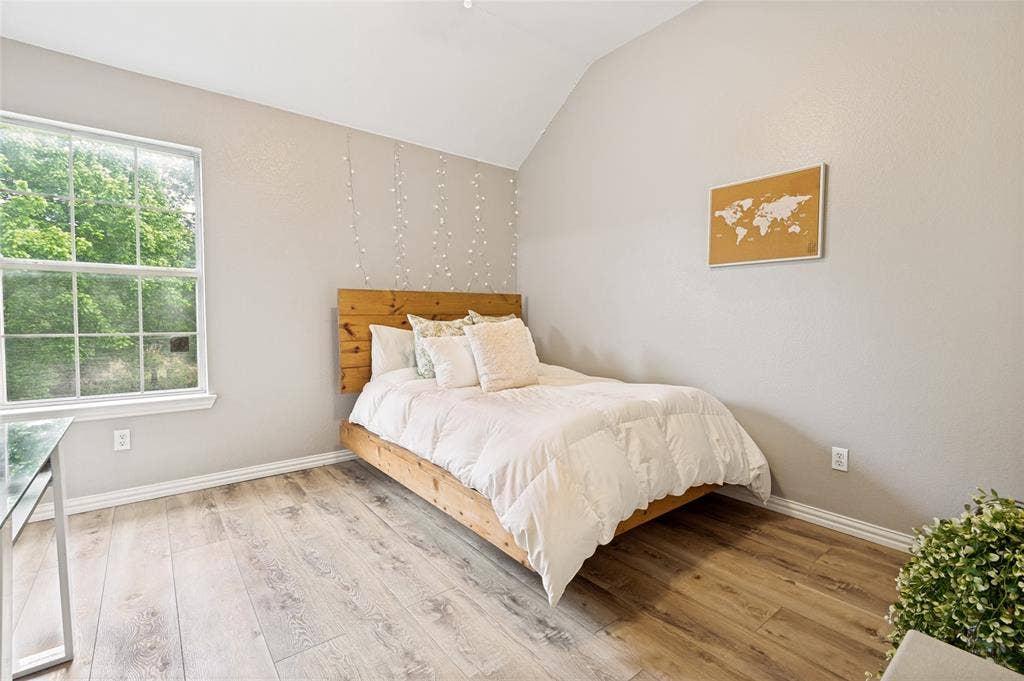 108 Appalachian Way, McKinney, TX 75071 Vaulted ceiling bedroom featuring wood-finish flooring, a large multi-pane window, and light-toned walls