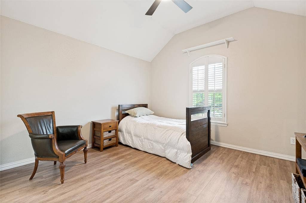 108 Appalachian Way, McKinney, TX 75071 Spacious room featuring vaulted ceilings, wood-finish flooring, a contemporary ceiling fan, and an arched window with plantation shutters