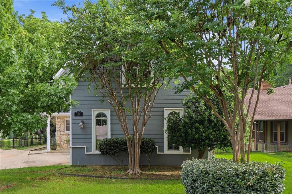 413 Collins Street, Argyle, TX 76226 Exterior featuring grey horizontal siding, arched entry doors, white trim, and a manicured lawn