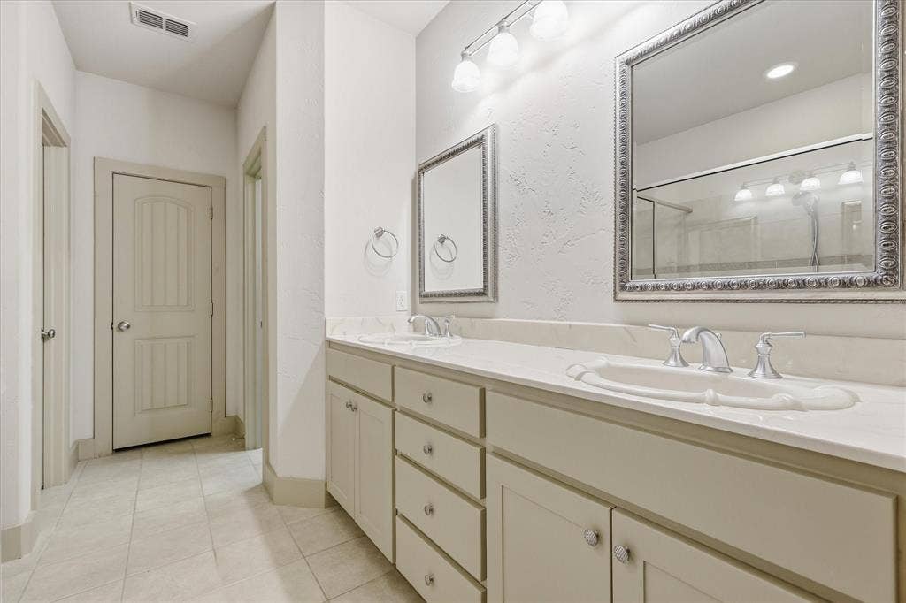 413 Collins Street, Argyle, TX 76226 Spacious bathroom featuring a dual vanity with integrated sinks, light-toned countertop, and framed mirrors