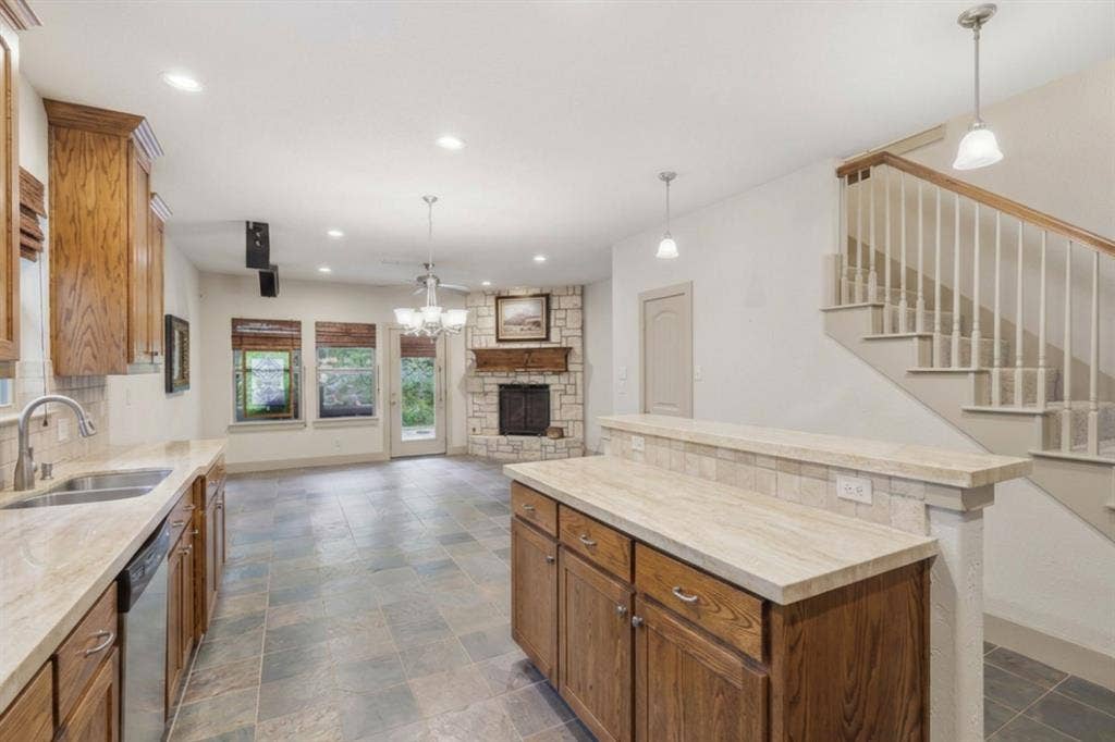 413 Collins Street, Argyle, TX 76226 Kitchen with integrated stainless steel dishwasher, double basin sink, and wood cabinetry
