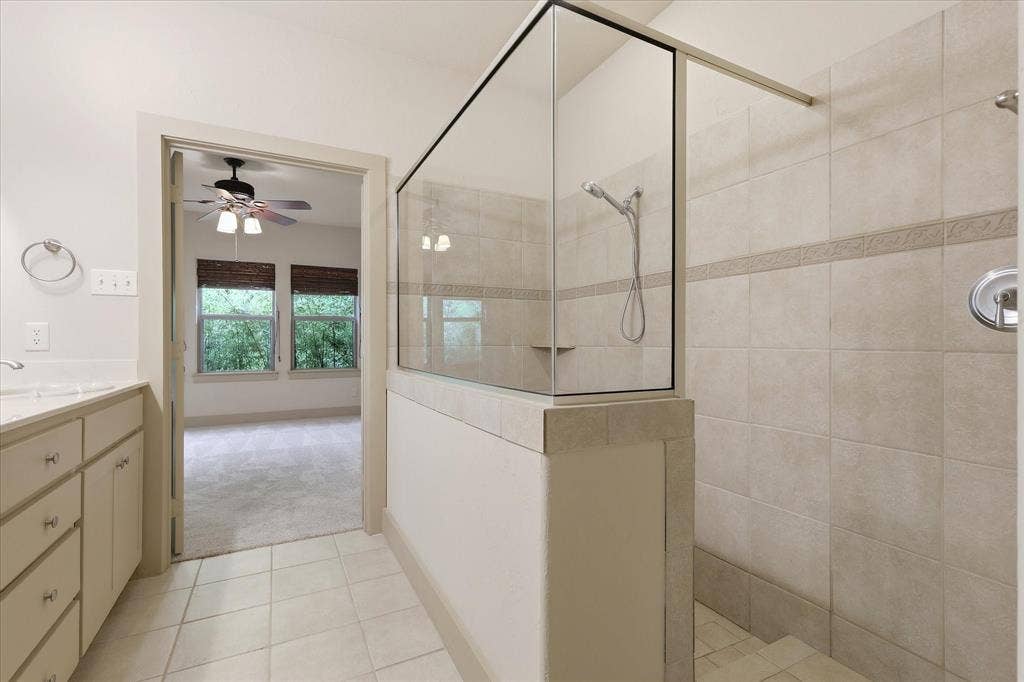 413 Collins Street, Argyle, TX 76226 Spacious bathroom featuring a glass-enclosed shower with tiled walls and a built-in shelf