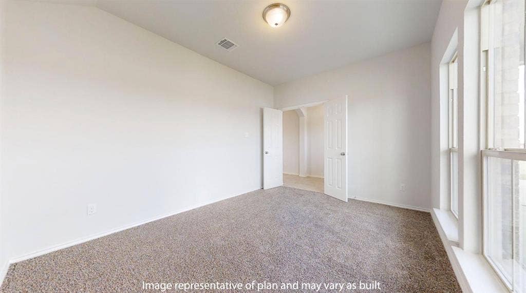 Carpeted room with white walls, a flush-mount ceiling light fixture, and a large window with vertical blinds