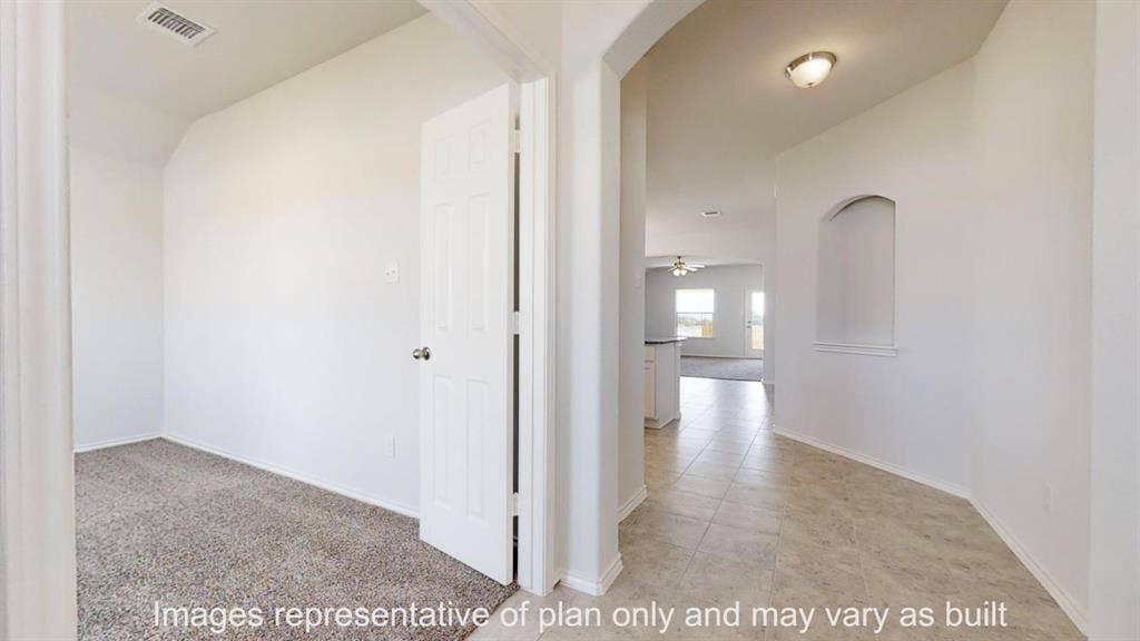 Entryway featuring neutral-toned tile flooring, an arched ceiling, and an integrated wall niche