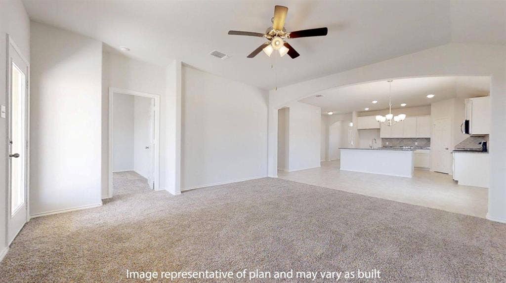 Spacious living area featuring neutral carpeting and a ceiling fan with integrated lighting