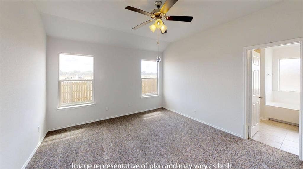 Spacious bedroom with vaulted ceiling, two windows, ceiling fan with light fixture, and carpeted flooring