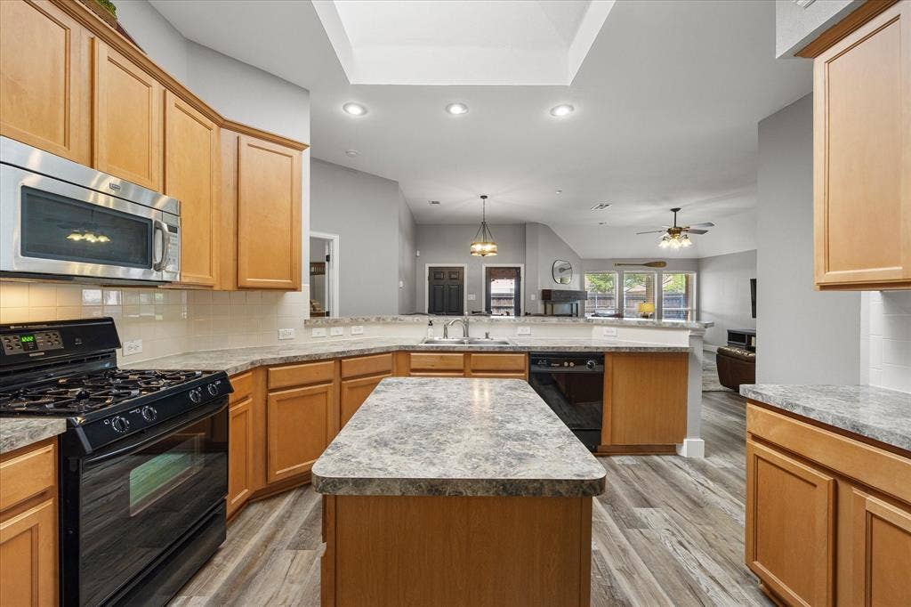 . The light and bright kitchen is the heart of the home, with granite-look counters, breakfast bar, prep island and gas range.