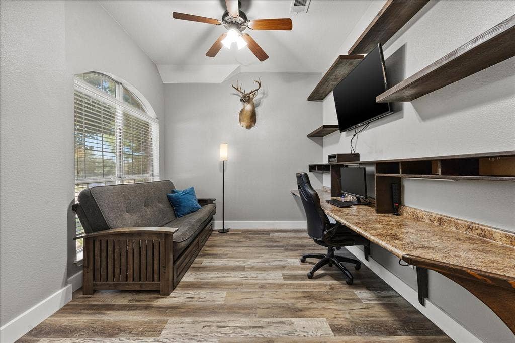 The handsome office boasts a custom floating multi-station desk and shelving.