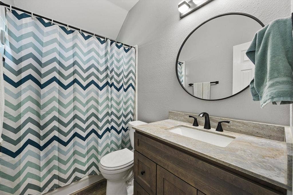 The hall bath has been updated with a granite-topped vanity, mirror, lighting, fixtures and hardware.