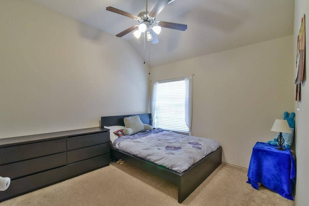2705 Fox Creek Trail, Arlington, TX 76017 Bedroom with vaulted ceiling, ceiling fan with light fixture, window with blinds, and neutral carpet flooring