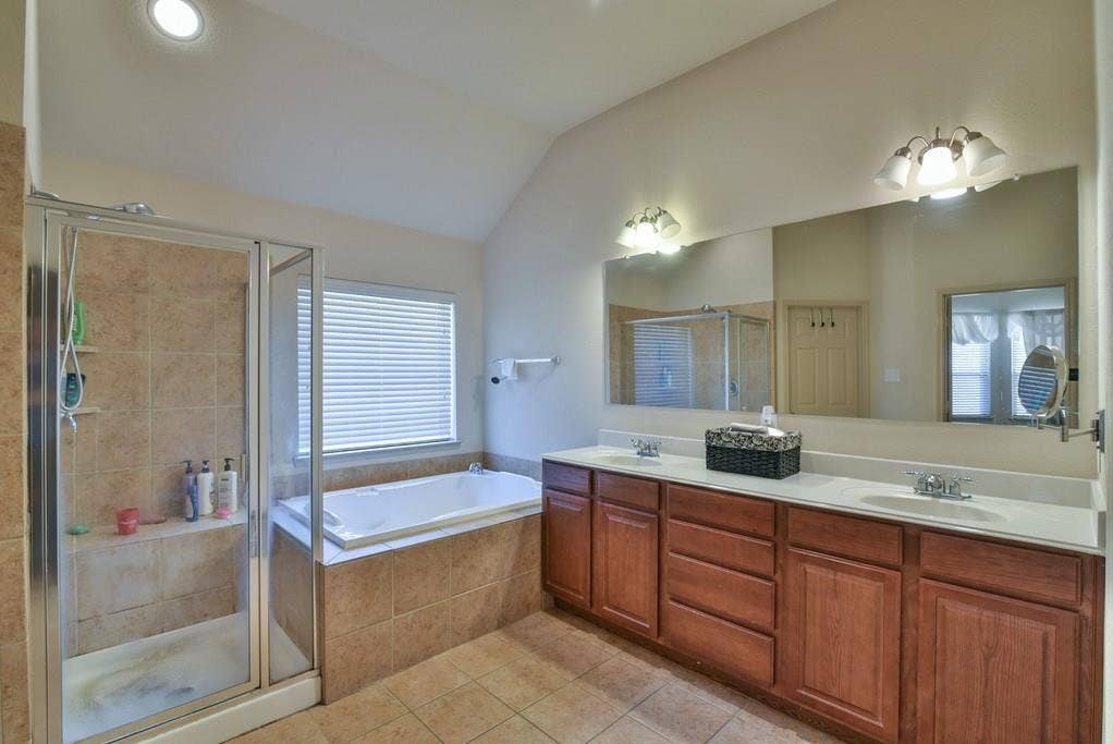 2705 Fox Creek Trail, Arlington, TX 76017 Spacious bathroom featuring a dual vanity with wood cabinetry and an expansive mirror