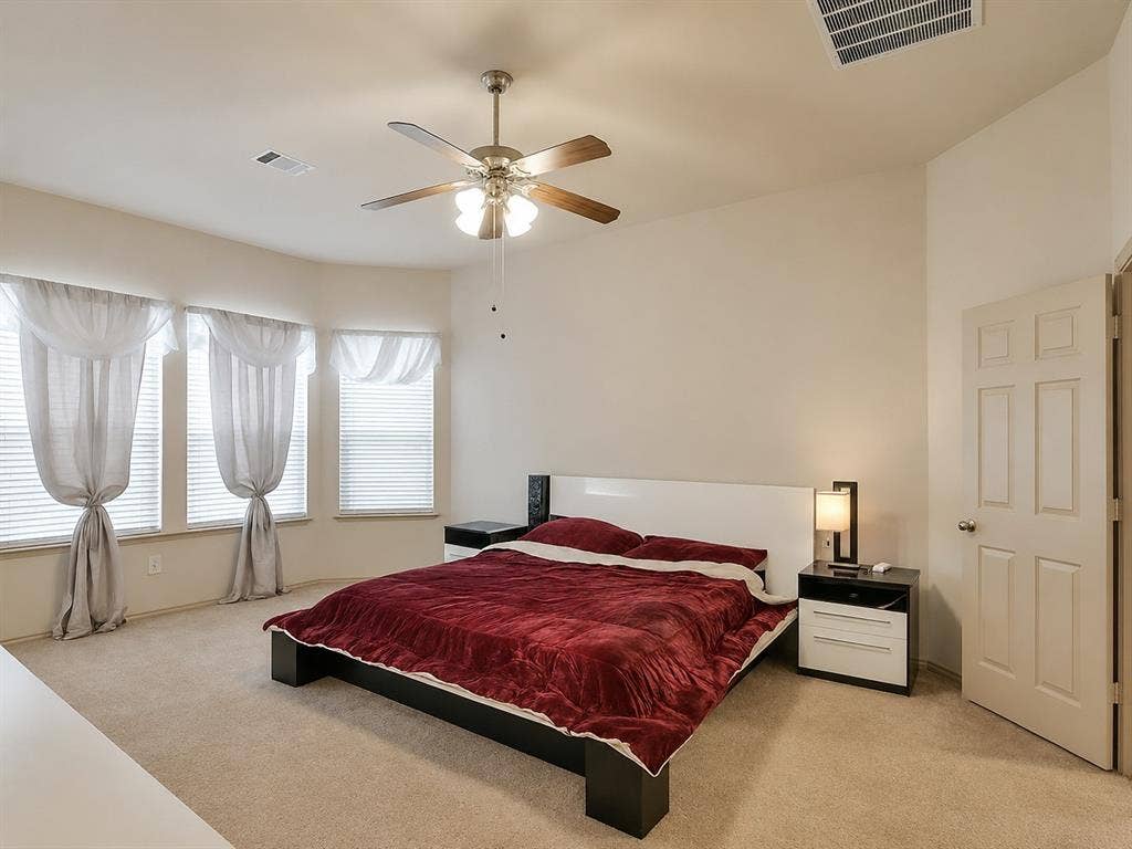 2705 Fox Creek Trail, Arlington, TX 76017 Carpeted room featuring a ceiling fan with light fixture, multiple windows with blinds, and a paneled interior door
