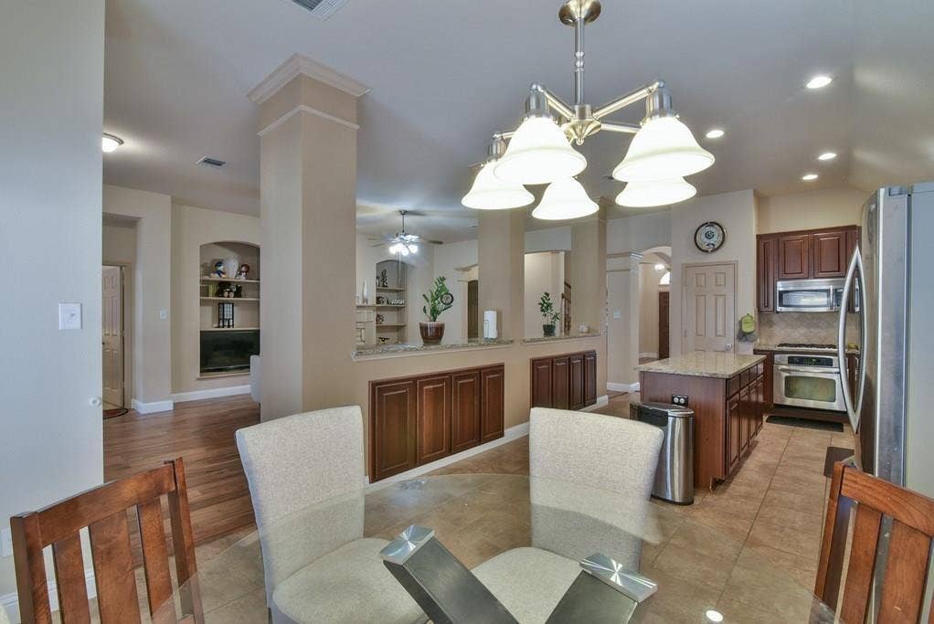 2705 Fox Creek Trail, Arlington, TX 76017 Spacious kitchen featuring dark wood cabinetry, stainless steel appliances, and a central island with granite countertop