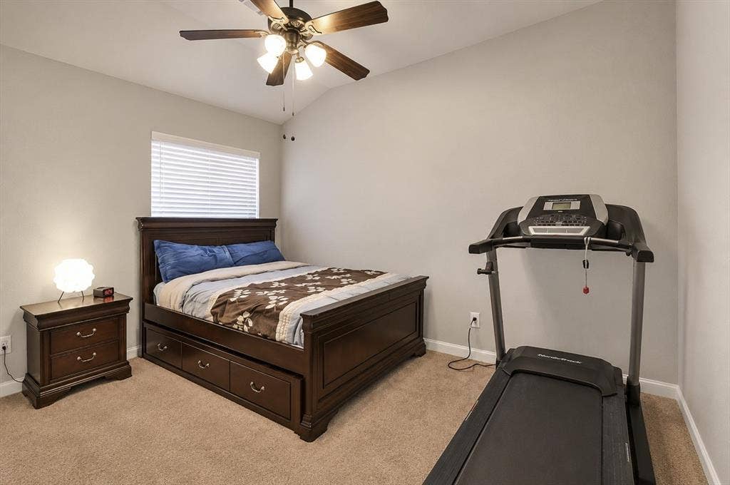 2705 Fox Creek Trail, Arlington, TX 76017 Bedroom featuring a vaulted ceiling with a ceiling fan, a window with horizontal blinds, and neutral carpeting
