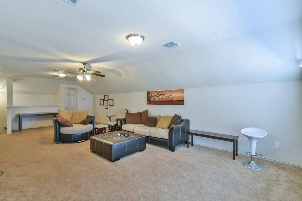 2705 Fox Creek Trail, Arlington, TX 76017 Spacious carpeted room featuring a sloped ceiling, recessed lighting, and dual ceiling fans