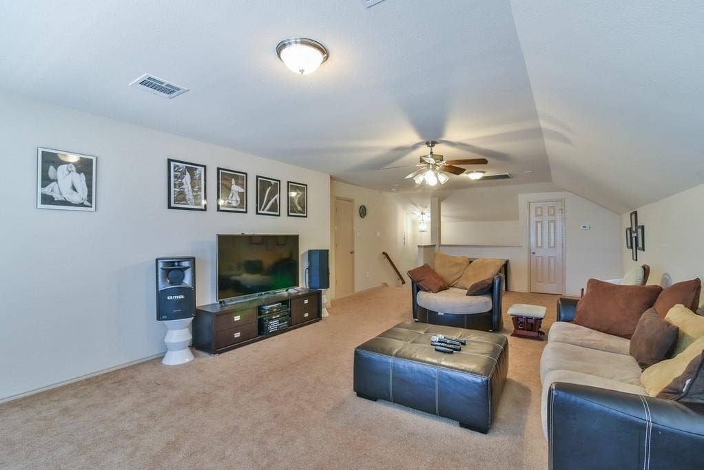 2705 Fox Creek Trail, Arlington, TX 76017 Carpeted recreation room featuring vaulted ceilings, a ceiling fan with integrated lighting, and a built-in media console