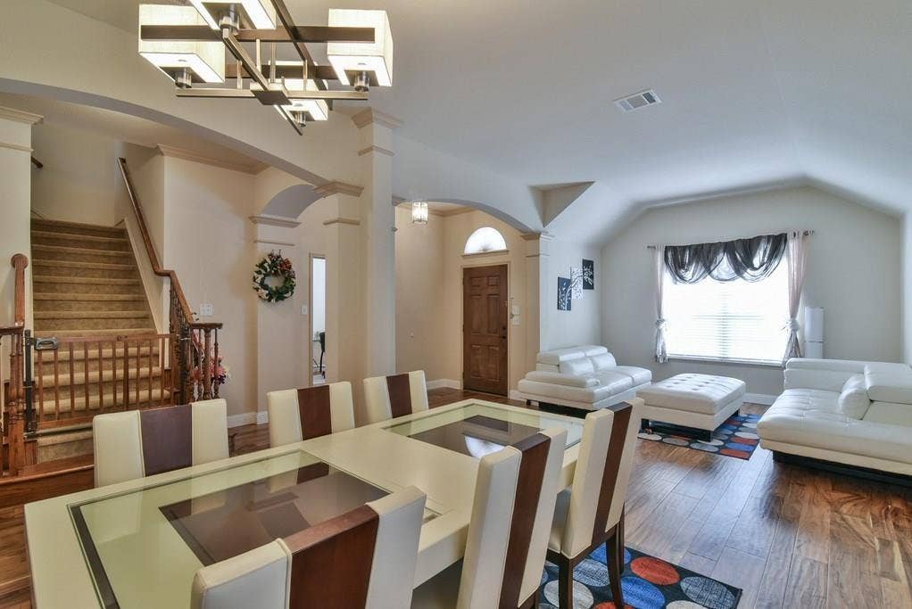 2705 Fox Creek Trail, Arlington, TX 76017 Spacious dining area with a modern chandelier and wood-finish flooring