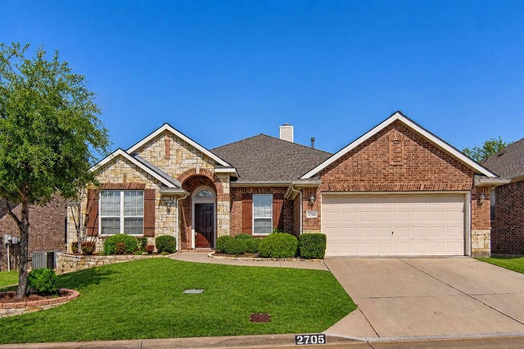 2705 Fox Creek Trail, Arlington, TX 76017 Stone and brick facade residence with an arched entry and dark wood front door