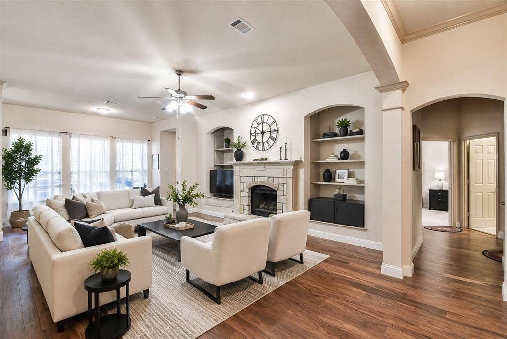 2705 Fox Creek Trail, Arlington, TX 76017 Wood-finish flooring, recessed lighting, ceiling fan, stone-surround fireplace with hearth, and built-in shelving with arched alcoves