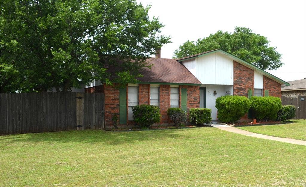 9615 Sophora Circle, Dallas, TX 75249 Brick exterior with white siding accents and a brown shingle roof