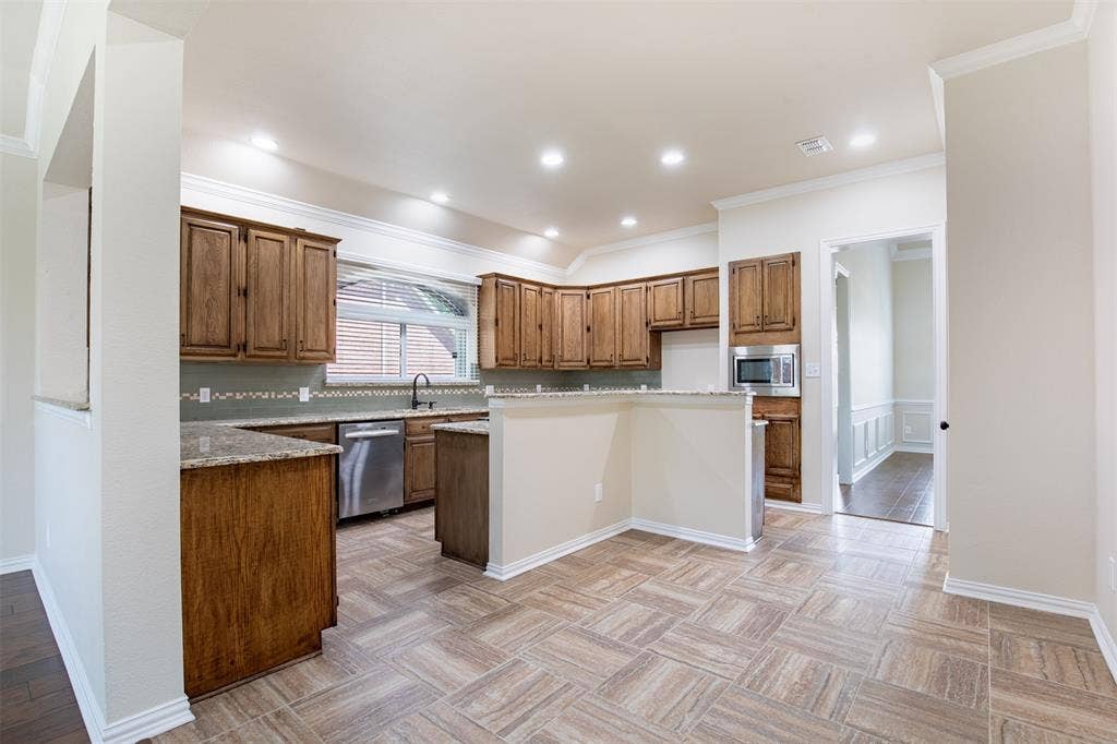 1405 Faringdon Drive, Plano, TX 75075 Gourmet kitchen features rich wood cabinetry.
