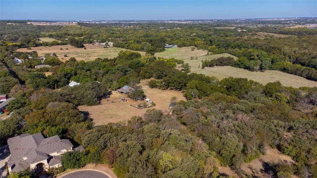 8601 Lowery Road, Fort Worth, TX 76120 Expansive wooded lot with a cleared building site featuring established fencing