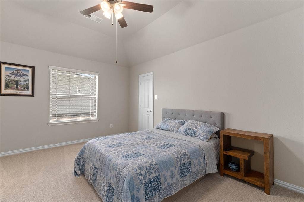 800 Beckington Drive, Shady Shores, TX 76208 Carpeted room featuring a vaulted ceiling with a ceiling fan, a window with horizontal blinds, and a white interior door