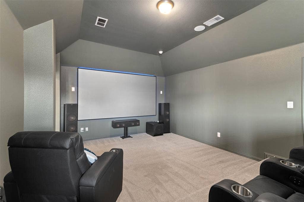 800 Beckington Drive, Shady Shores, TX 76208 Dedicated media room featuring a large projection screen, dark painted walls, vaulted ceilings, recessed ceiling lighting, and carpet flooring