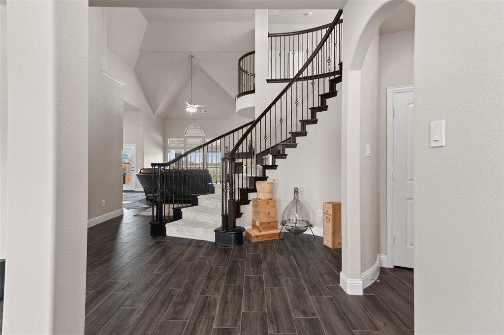 800 Beckington Drive, Shady Shores, TX 76208 Grand entry featuring a curved staircase with wrought iron balusters and carpeted treads