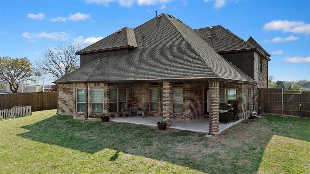 800 Beckington Drive, Shady Shores, TX 76208 Expansive backyard featuring a covered patio with brick columns, a full privacy fence, and a manicured lawn