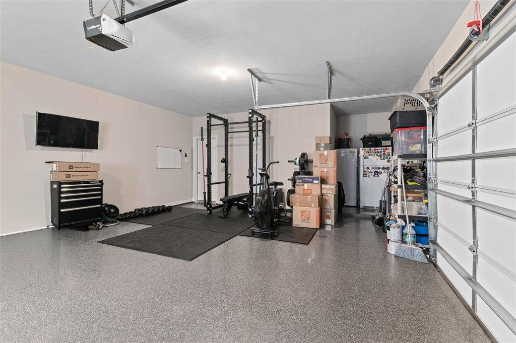 800 Beckington Drive, Shady Shores, TX 76208 Garage with light gray epoxy flooring and an overhead door opener mechanism