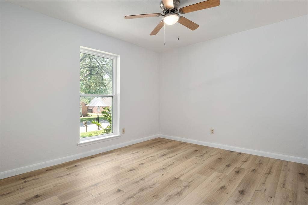 3406 Windridge Drive, Garland, TX 75043 Interior room featuring light wood-finish flooring, white walls, and a ceiling fan with integrated lighting