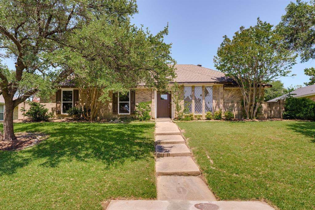 3406 Windridge Drive, Garland, TX 75043 Brick exterior featuring a gabled roof and a stepped concrete walkway
