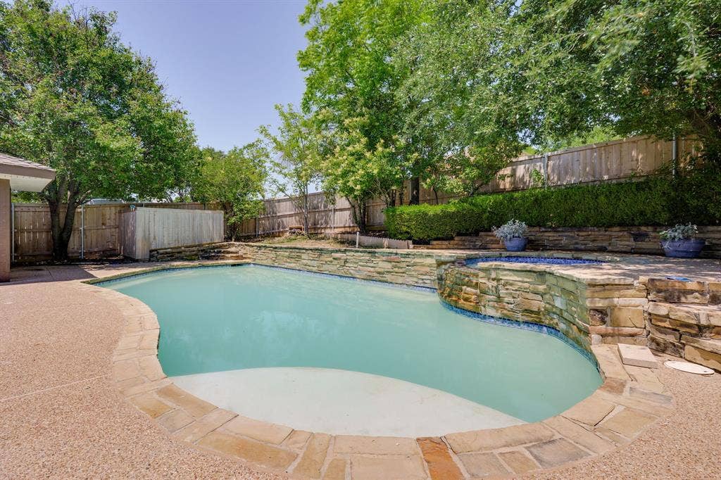3406 Windridge Drive, Garland, TX 75043 Freeform swimming pool with integrated spa and stone surround