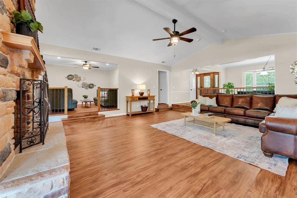 3908 Wildwood, Euless, TX 76040 Spacious living area featuring wood-finish flooring and a stone fireplace with hearth