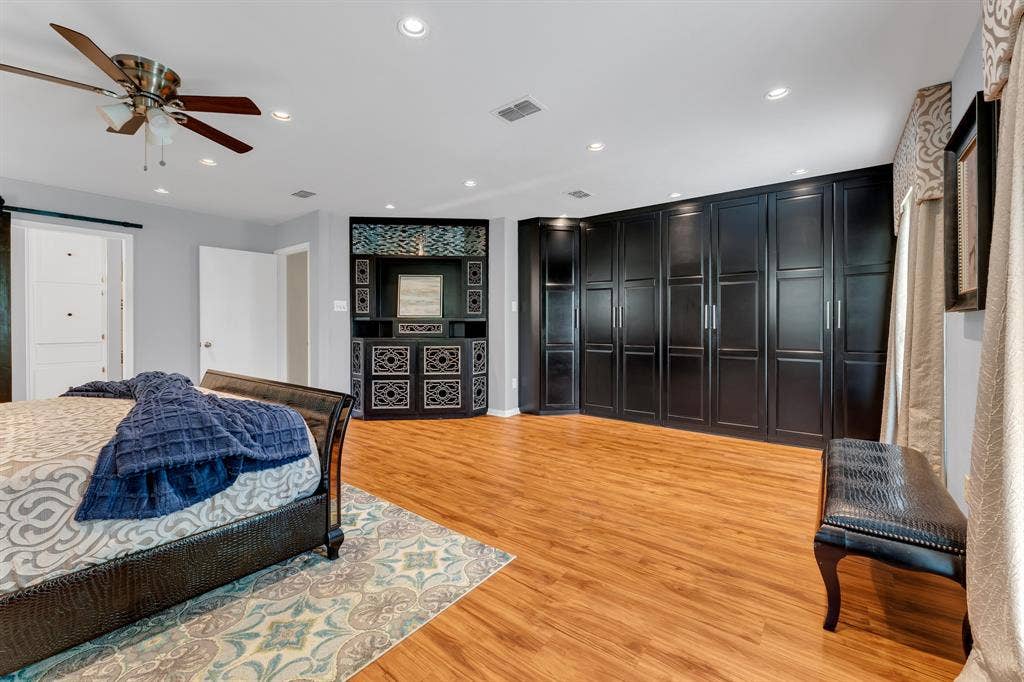3908 Wildwood, Euless, TX 76040 Expansive room featuring wood-finish flooring, recessed lighting, a ceiling fan, and extensive built-in cabinetry with dark panel doors