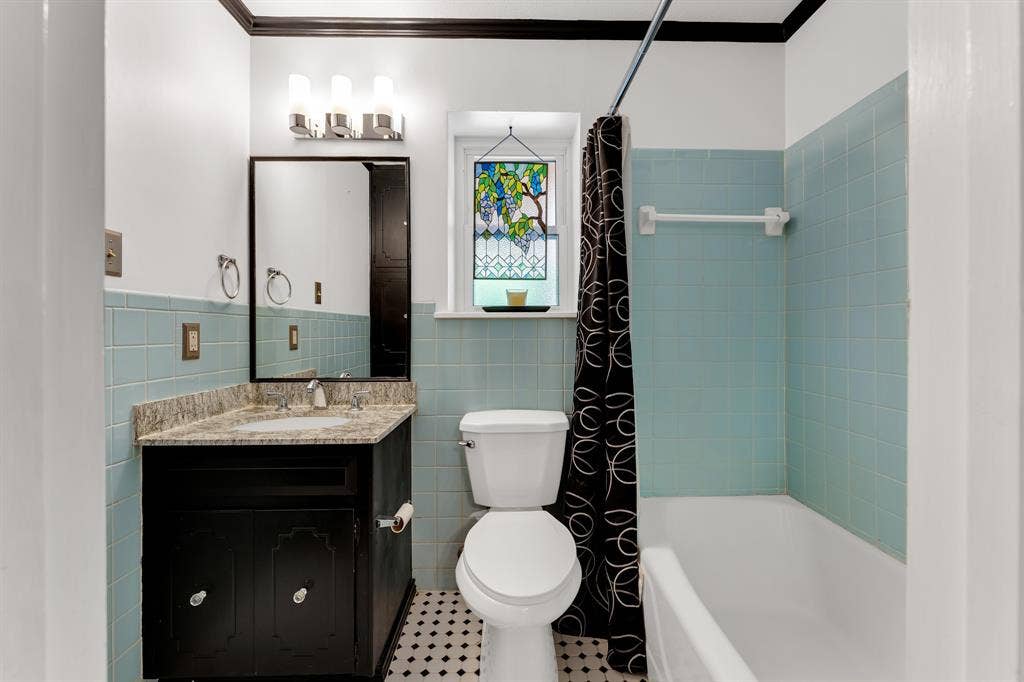 3908 Wildwood, Euless, TX 76040 Ensuite Bathroom featuring a vanity with a granite countertop, undermount sink, and black cabinetry