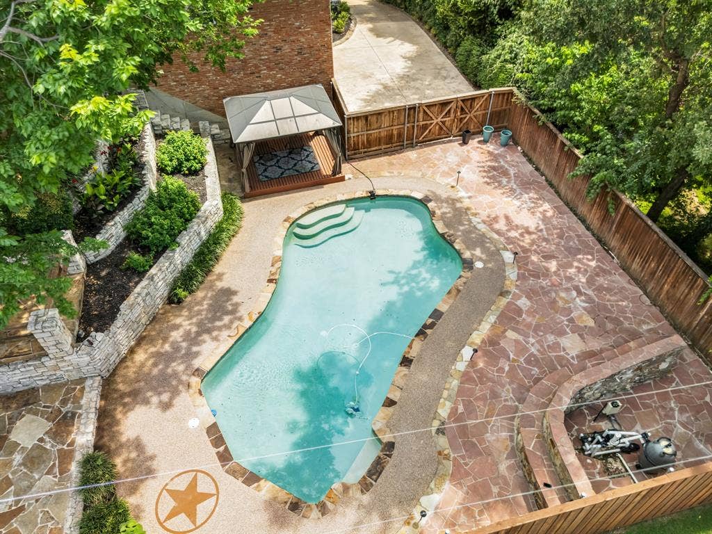 3908 Wildwood, Euless, TX 76040 Freeform swimming pool with integrated steps, surrounded by flagstone and aggregate decking
