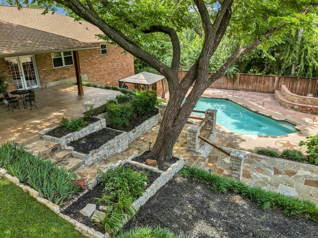 3908 Wildwood, Euless, TX 76040 Expansive backyard featuring a blue swimming pool, flagstone patio, and mature trees