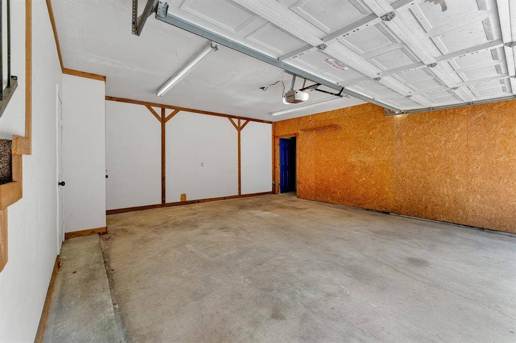 3908 Wildwood, Euless, TX 76040 Spacious garage with a concrete floor and white paneled garage door