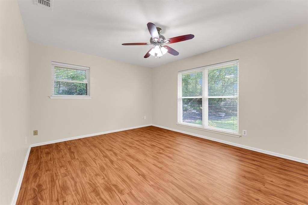 3908 Wildwood, Euless, TX 76040 Spacious bedroom #2 with wood-finish flooring, light neutral wall paint, and white baseboards