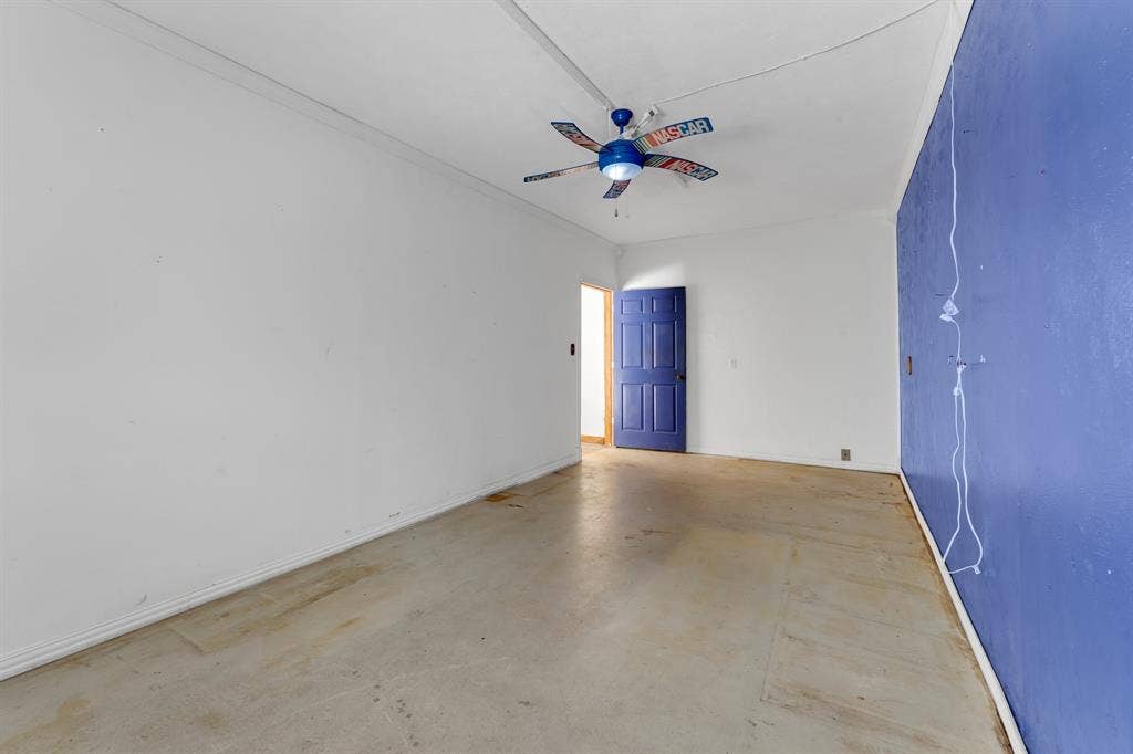 3908 Wildwood, Euless, TX 76040 Spacious room featuring a vibrant blue accent wall, a contrasting white wall, and a blue paneled door