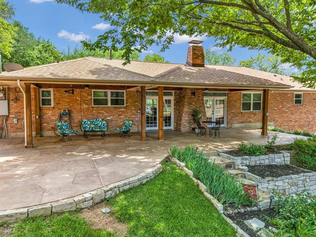 3908 Wildwood, Euless, TX 76040 Expansive patio featuring a covered area with exposed wood beams, a stamped concrete surface, and direct access through multiple sets of double doors