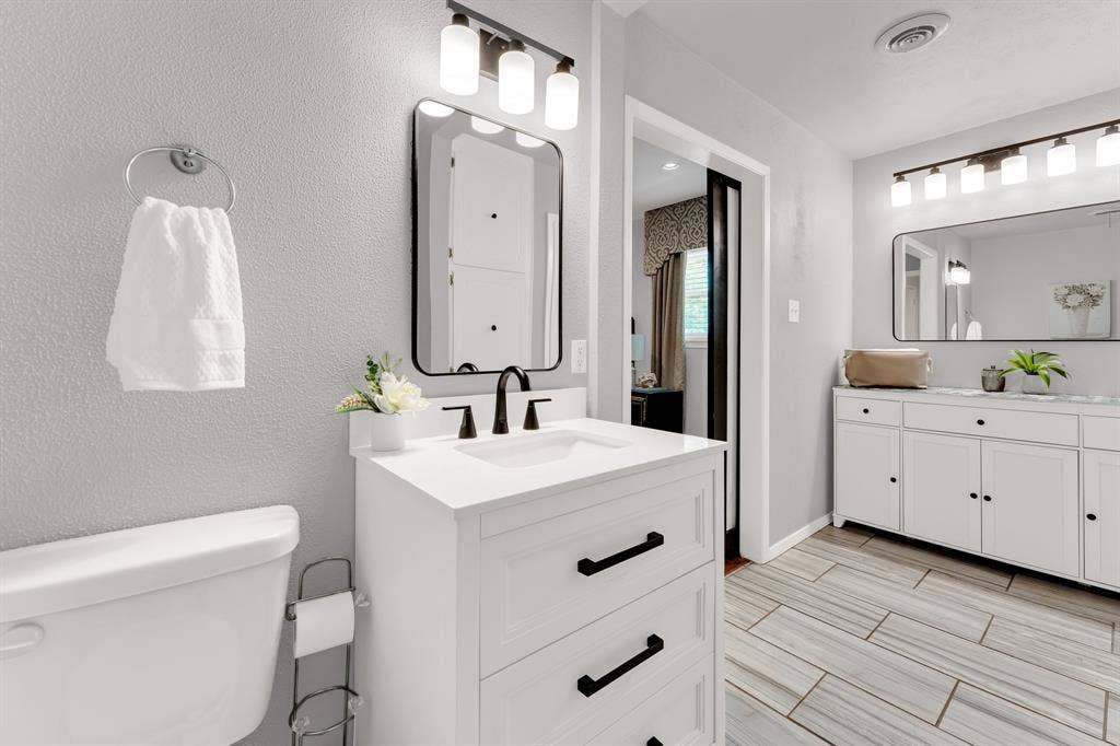 3908 Wildwood, Euless, TX 76040 Contemporary bathroom featuring a white vanity with matte black hardware, an undermount sink, and a black-framed mirror